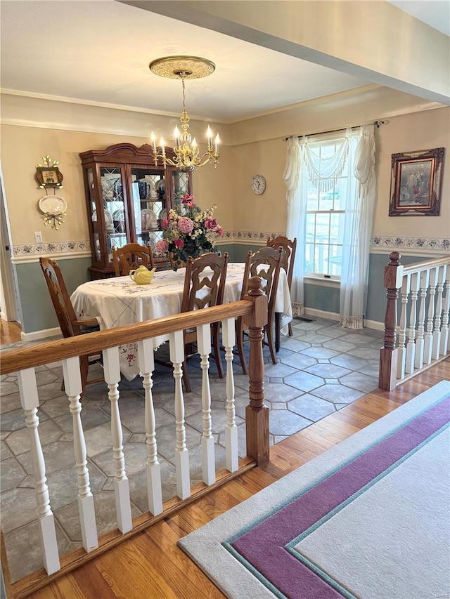 dining area with a chandelier, baseboards, and wood finished floors