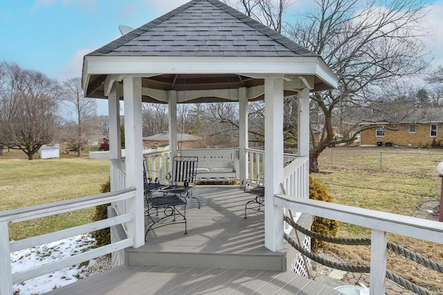 wooden deck featuring a gazebo, a yard, and fence