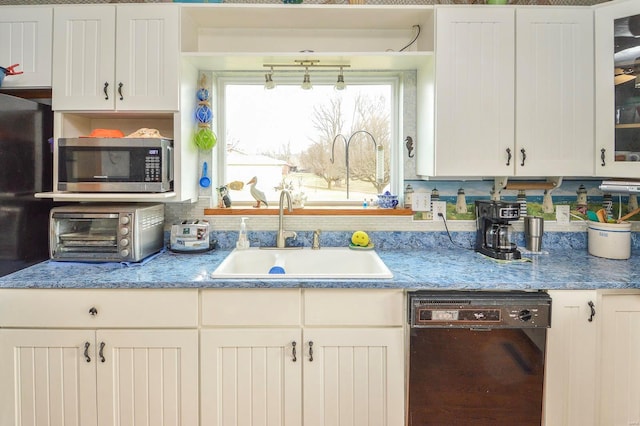 kitchen with a toaster, a sink, black dishwasher, glass insert cabinets, and stainless steel microwave