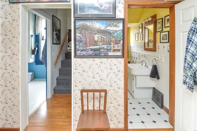 interior space with light wood-type flooring, visible vents, stairway, and wallpapered walls