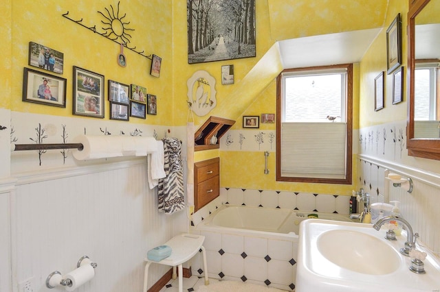 bathroom featuring a garden tub and a sink