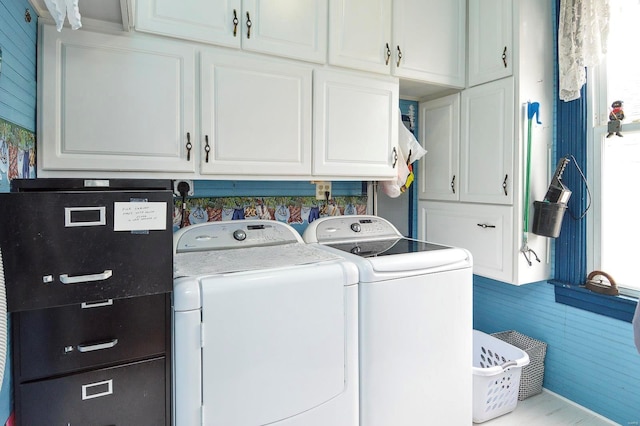 clothes washing area featuring cabinet space and washing machine and clothes dryer