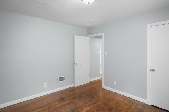 unfurnished bedroom with wood finished floors, visible vents, and baseboards