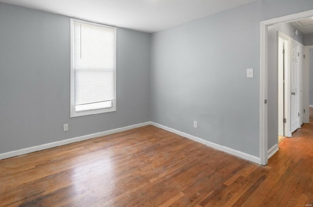 empty room with baseboards and wood finished floors