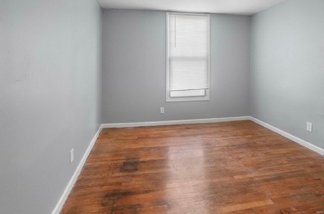 spare room with wood finished floors and baseboards