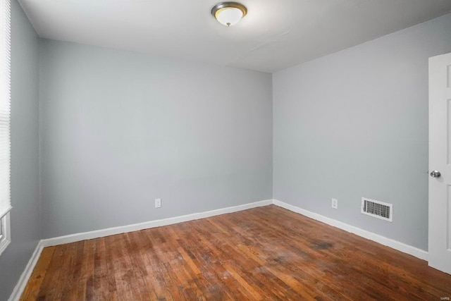 unfurnished room featuring wood finished floors, baseboards, and visible vents