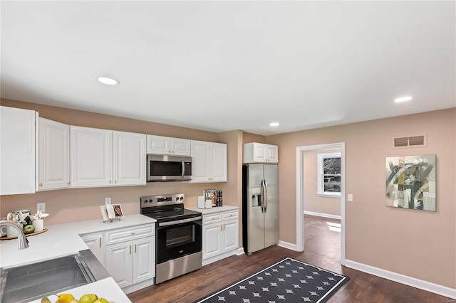 kitchen with visible vents, light countertops, white cabinets, stainless steel appliances, and a sink