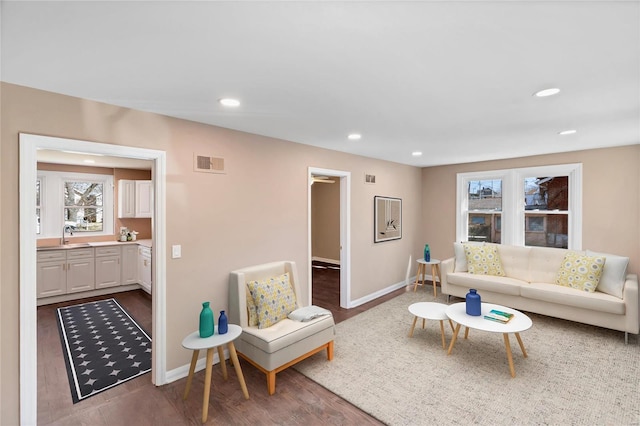 living area featuring visible vents, recessed lighting, baseboards, and wood finished floors