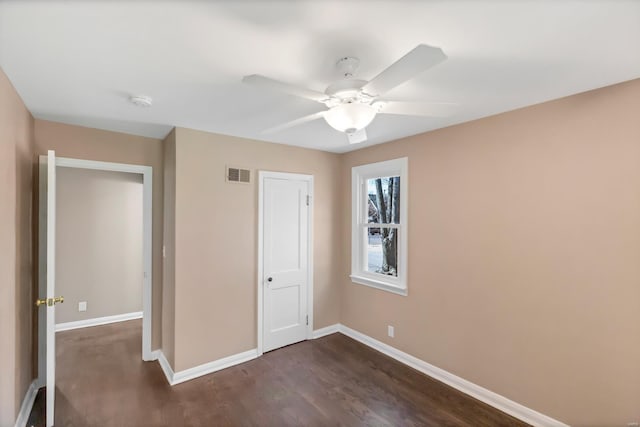 unfurnished bedroom featuring visible vents, baseboards, ceiling fan, and dark wood-style flooring