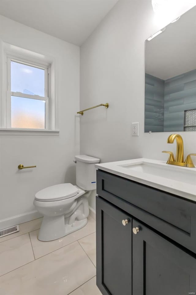 bathroom featuring tile patterned flooring, visible vents, baseboards, toilet, and vanity