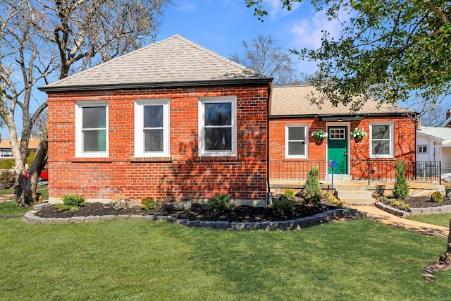 view of front facade with a front lawn, a garage, brick siding, and a shingled roof