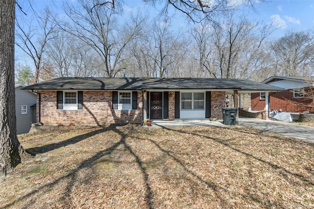 ranch-style home featuring a carport, driveway, and brick siding