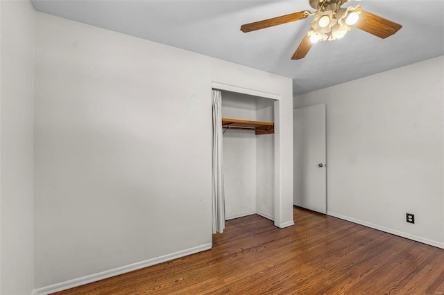 unfurnished bedroom with a closet, baseboards, wood finished floors, and a ceiling fan