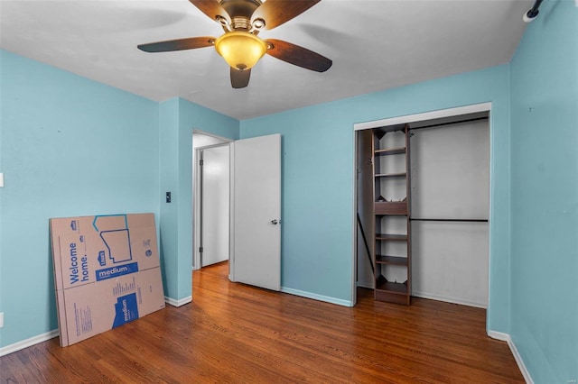 unfurnished bedroom featuring a closet, a ceiling fan, baseboards, and wood finished floors