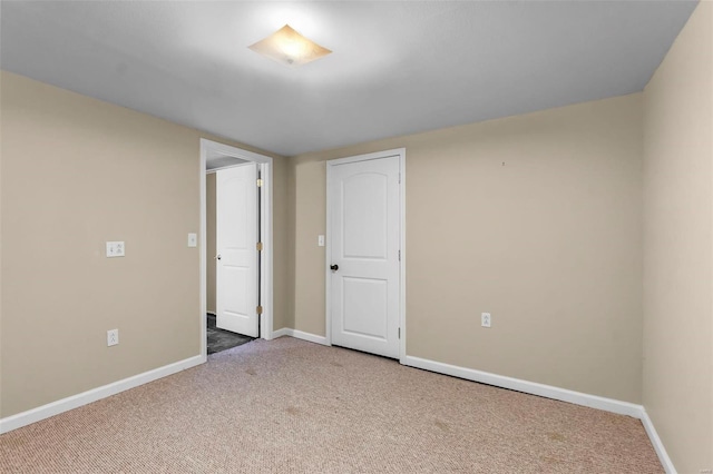 spare room featuring baseboards and carpet floors