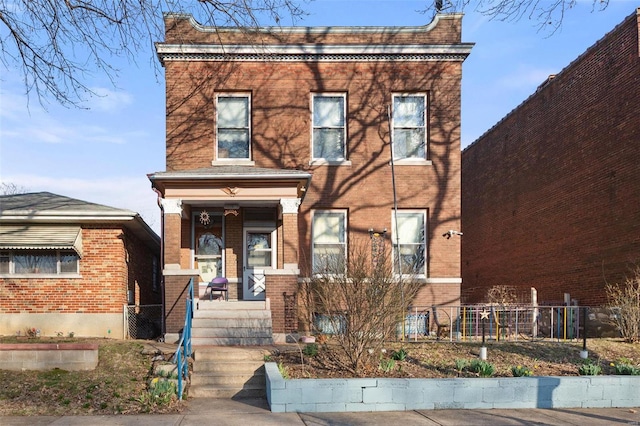 view of front of property with brick siding and fence