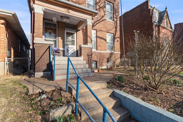 view of front of house with brick siding and fence