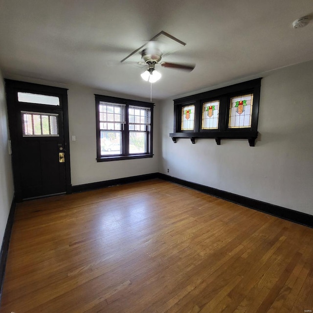 interior space featuring baseboards, wood finished floors, and a ceiling fan