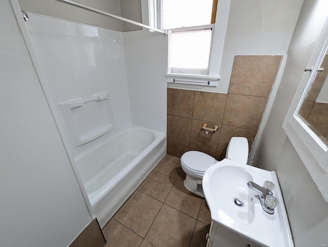 full bathroom featuring toilet, vanity, bathing tub / shower combination, tile patterned floors, and tile walls