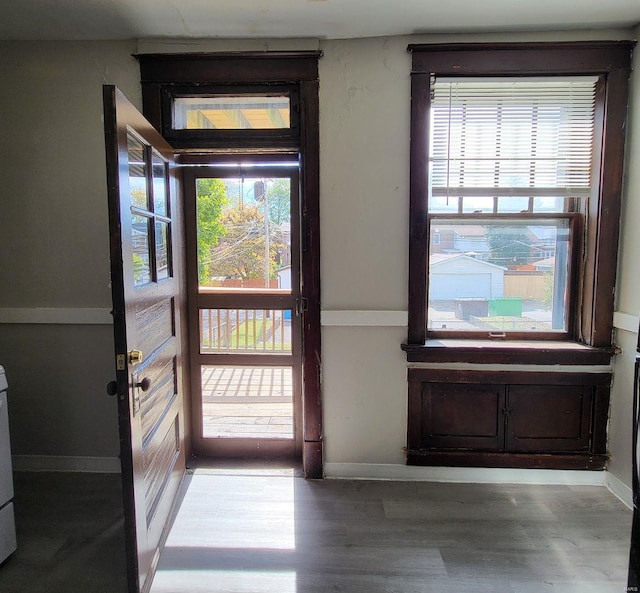 doorway to outside featuring baseboards and wood finished floors