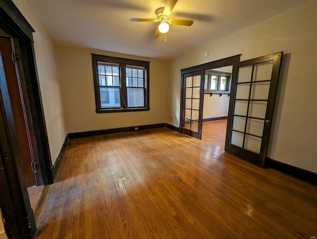 unfurnished room featuring a ceiling fan, baseboards, and wood-type flooring