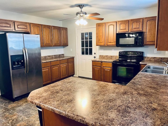 kitchen featuring ceiling fan, brown cabinets, a peninsula, black appliances, and a sink