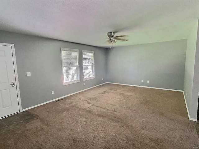 unfurnished room featuring baseboards, carpet, ceiling fan, and a textured ceiling