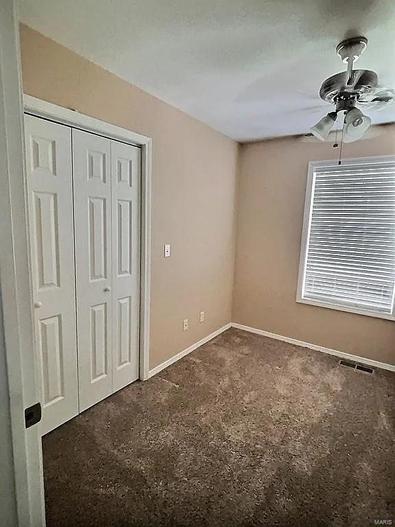 unfurnished bedroom featuring visible vents, baseboards, a closet, and a ceiling fan