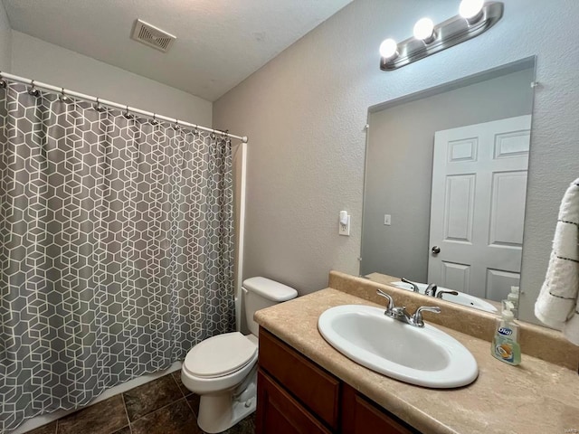 full bathroom featuring vanity, a shower with shower curtain, visible vents, toilet, and a textured wall