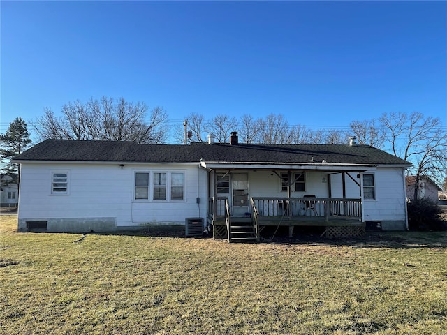 back of property with a yard, central AC unit, a chimney, and a shingled roof