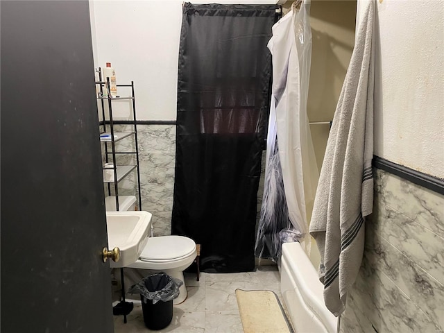 full bath featuring a wainscoted wall, tile walls, toilet, and marble finish floor