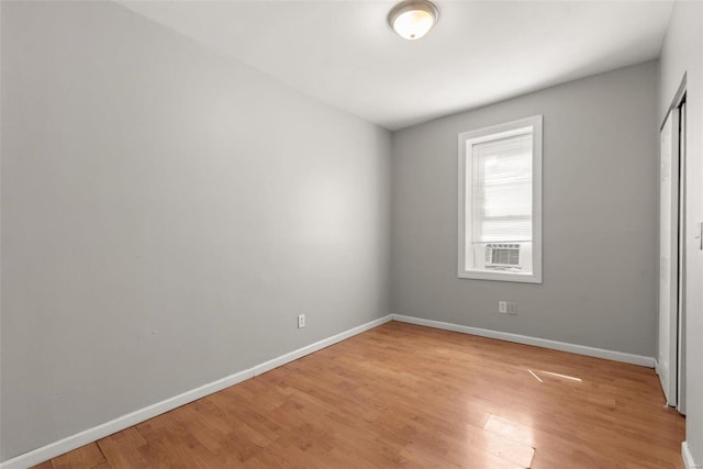 unfurnished bedroom with a closet, light wood-type flooring, and baseboards