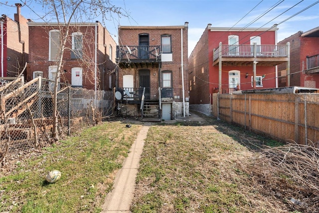 rear view of house with fence and brick siding