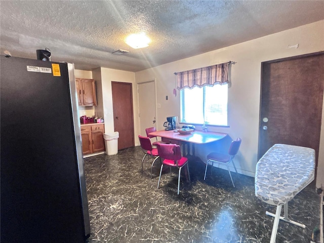 dining space with visible vents and a textured ceiling