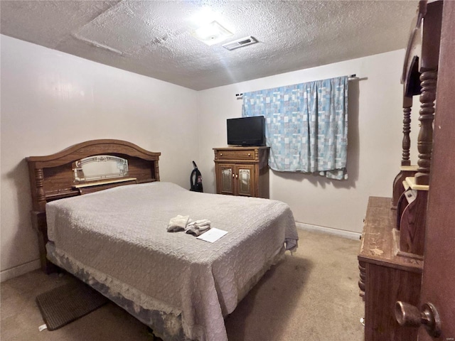 carpeted bedroom featuring visible vents, baseboards, and a textured ceiling