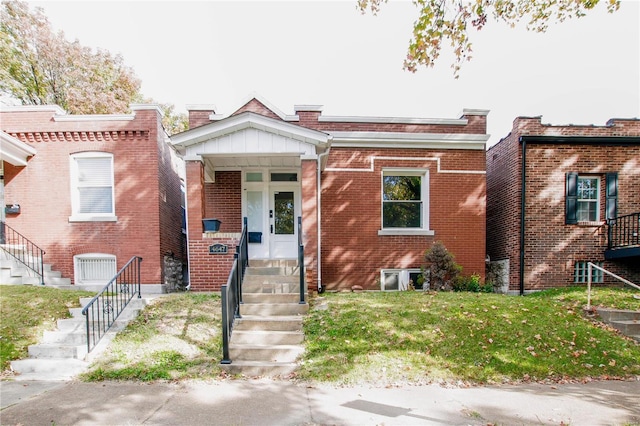 view of front facade with brick siding and a front lawn