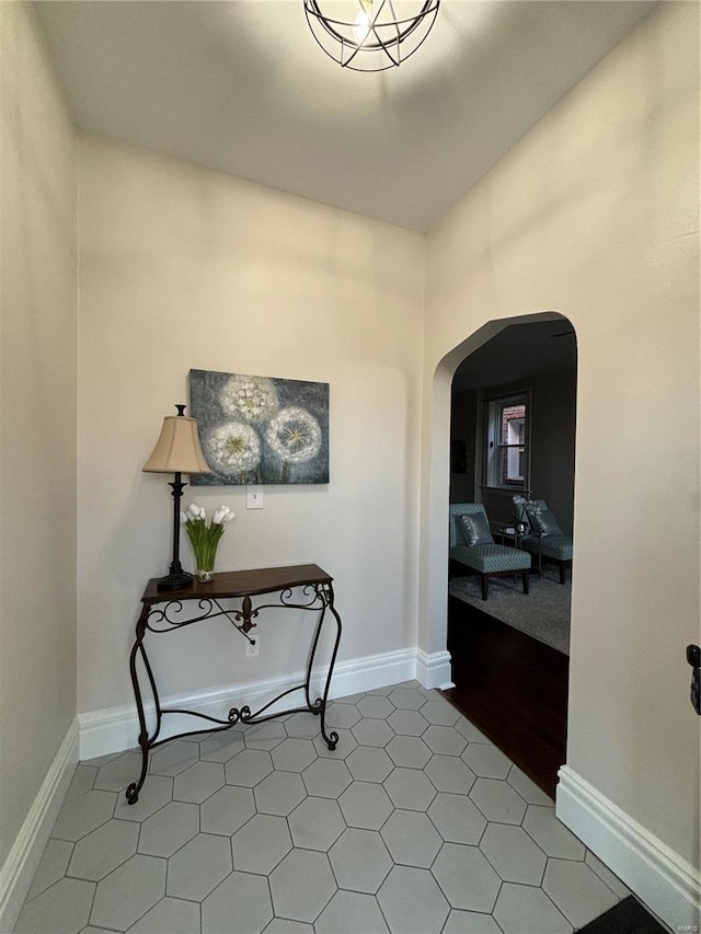 interior space with baseboards and arched walkways