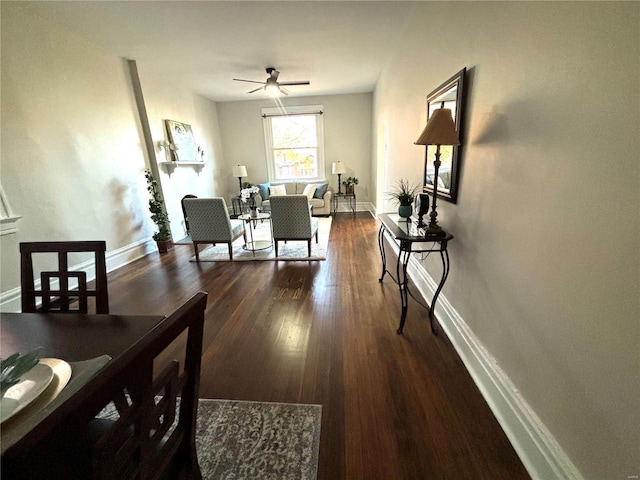 dining area with baseboards, ceiling fan, and dark wood finished floors