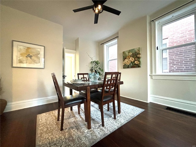 dining space featuring visible vents, baseboards, dark wood-style floors, and ceiling fan