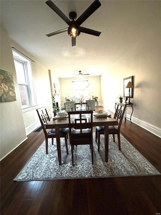 dining room featuring baseboards, a ceiling fan, and wood finished floors