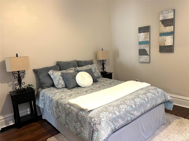 bedroom featuring baseboards and dark wood-style flooring