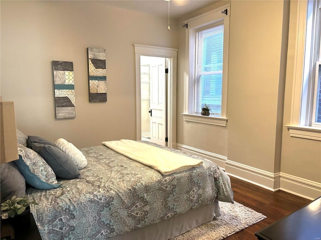 bedroom featuring baseboards and dark wood-style flooring