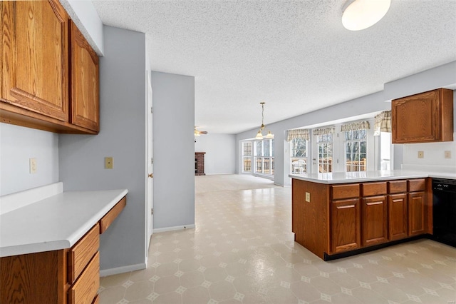 kitchen with ceiling fan, light countertops, black dishwasher, brown cabinets, and a peninsula