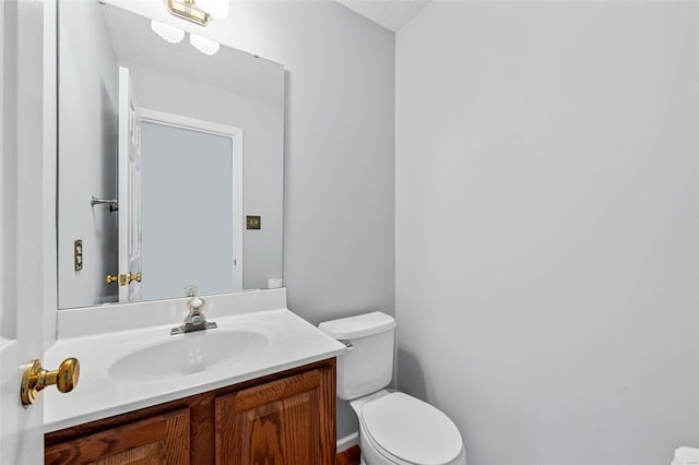 half bathroom with vanity and toilet