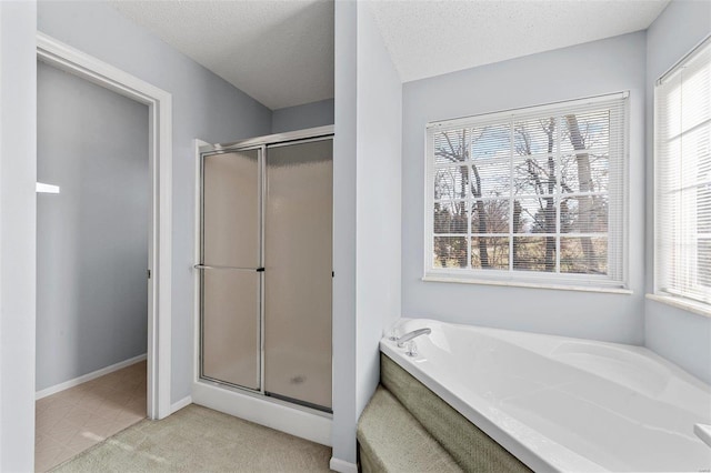 bathroom with baseboards, a garden tub, a stall shower, and a textured ceiling