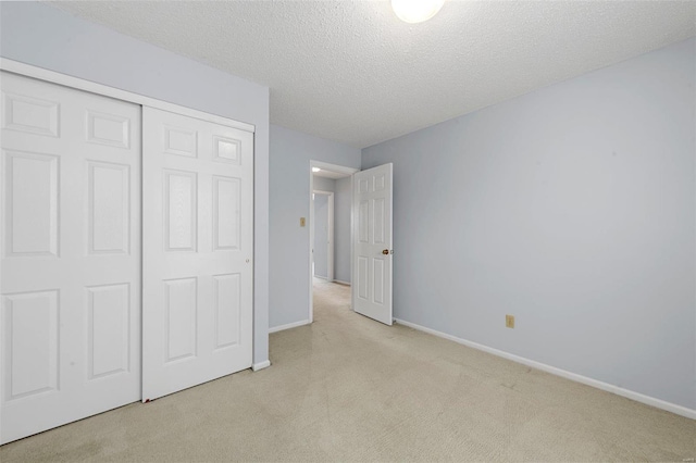 unfurnished bedroom featuring a closet, baseboards, a textured ceiling, and carpet flooring