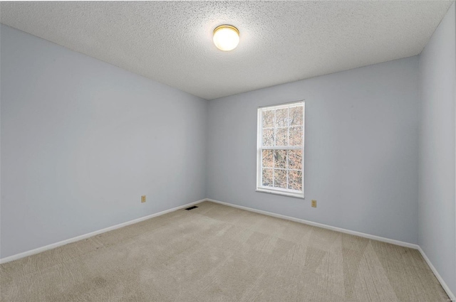 carpeted spare room with baseboards and a textured ceiling