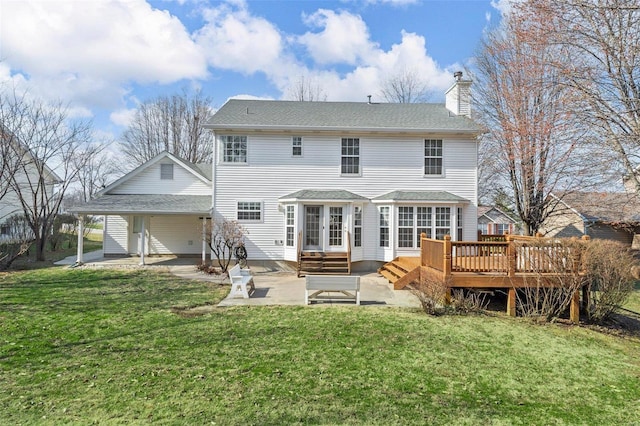 rear view of house featuring a yard, entry steps, a chimney, and a patio