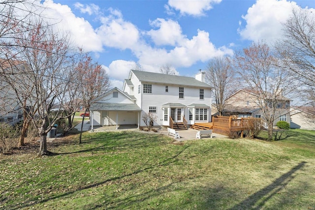 back of house with entry steps, a lawn, a garage, and a chimney