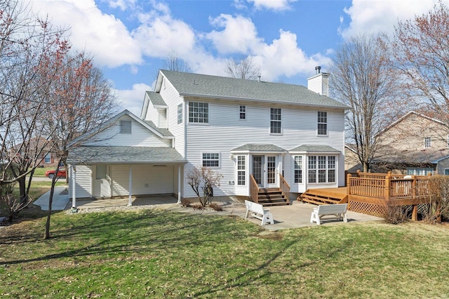 back of house with entry steps, a wooden deck, a chimney, a yard, and a patio